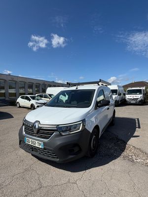 une camionnette blanche garée sur un parking à côté d'un bâtiment
