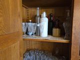une armoire en bois sur laquelle sont posés de nombreux verres et bouteilles
