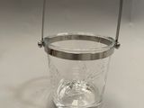a glass bucket with a handle on a white table