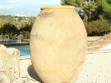 a large vase that is sitting on the ground by the pool