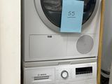 two washers and a dryer stacked on top of each other in a room