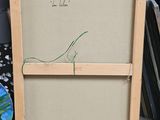 a picture of a painting on a easel next to a pile of books