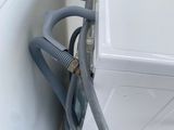 an image of a washing machine with a hose attached to the side of it