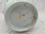 a white cup with a yellow bird on it