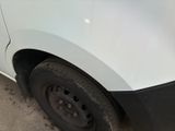 a white van with black rims parked on the street