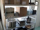 des étagères sur lesquelles sont posées des casseroles et des poêles dans une cuisine