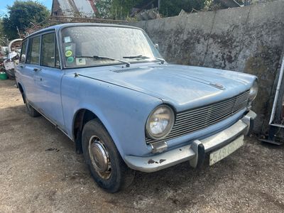 une petite voiture bleue garée devant un mur