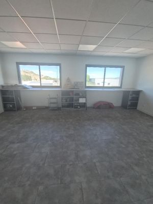 une pièce vide avec de nombreuses fenêtres et un bureau