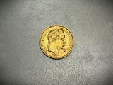 a close up of a gold coin on a gray surface