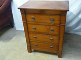 une petite commode en bois dans un coin de la pièce