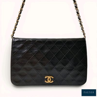un sac à bandoulière Chanel en cuir noir avec des finitions dorées