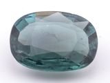 a close up of a blue green gemstone on a white surface