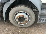 un pneu crevé sur un camion garé sur un terrain en terre battue