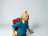 a figurine of a man with a backpack on his back