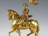 bronze statue of a man on a horse holding a flag
