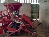 a red tractor that is parked in a barn