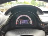 a car dashboard with a digital speedometer and a steering wheel