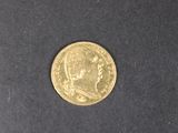 a close up of a gold coin on a black surface