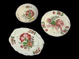 trois assiettes ornées de motifs floraux sur fond noir