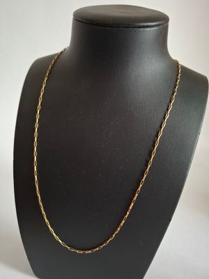 a black mannequin with a gold chain on it