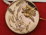 une broche en or ornée d'un chat et de fleurs