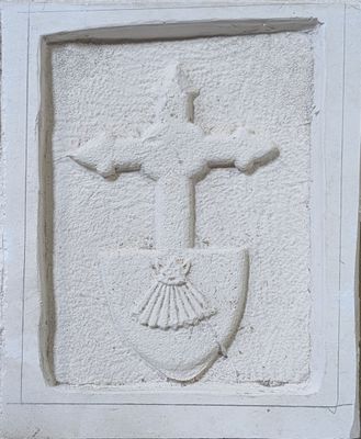 a cross and a shield on the wall of a building