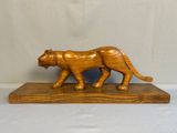 figurine en bois sculpté représentant un tigre, posée sur un socle en bois