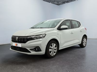 Une voiture blanche est garée dans une pièce blanche au sol noir.