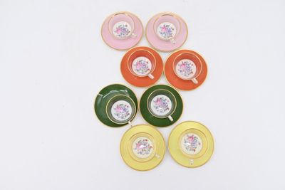 several tea cups and saucers are lined up on a white surface