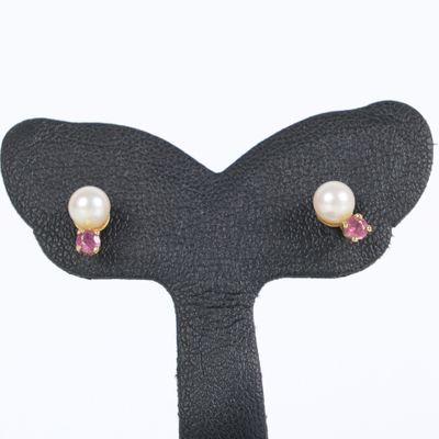 a close up of a pair of earrings on a black stand