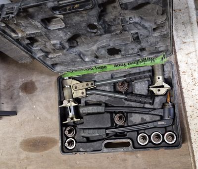 une trousse à outils dans une mallette posée par terre