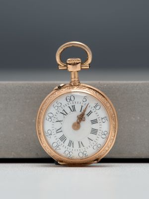a gold pocket watch with roman numerals on it
