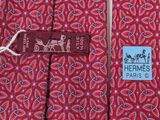two red ties with blue and white designs on them with a tag