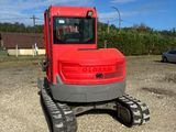 a red tractor that is parked in the dirt