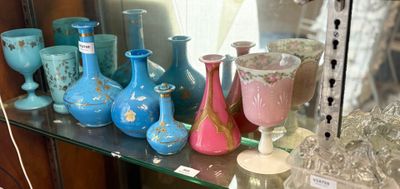 de nombreux vases de différentes couleurs posés sur une étagère en verre