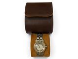 brown leather watch case with a watch inside of it on a white surface