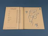 un livre ouvert, orné d'un dessin, posé sur une surface bleue