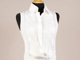 une femme vêtue d'une chemise blanche et d'une jupe noire, avec un foulard blanc autour du cou