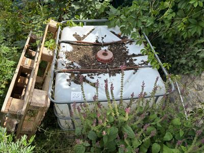 un réservoir blanc posé au milieu d'un jardin