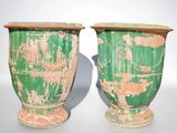 deux vases verts posés l'un à côté de l'autre sur une table