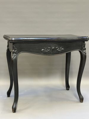 Table à jeux en bois noirci, piètement galbé, à décor de fle…