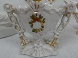 a small white vase with a gold decoration on it