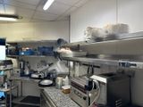 une cuisine avec beaucoup de plans de travail et de nombreux appareils électroménagers
