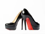 a close up of a pair of black high heels on a white surface