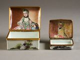 two small boxes with paintings on them sitting on a table