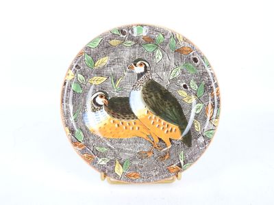 deux oiseaux posés sur une assiette décorée de feuilles