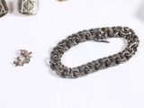some silver jewelry is laying out on a white surface