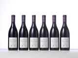 six bottles of wine lined up in a row on a table