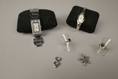 deux montres et une paire de boucles d'oreilles posées sur une table