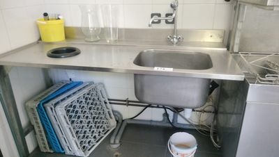 a sink in a small kitchen with a lot of dishes on the counter